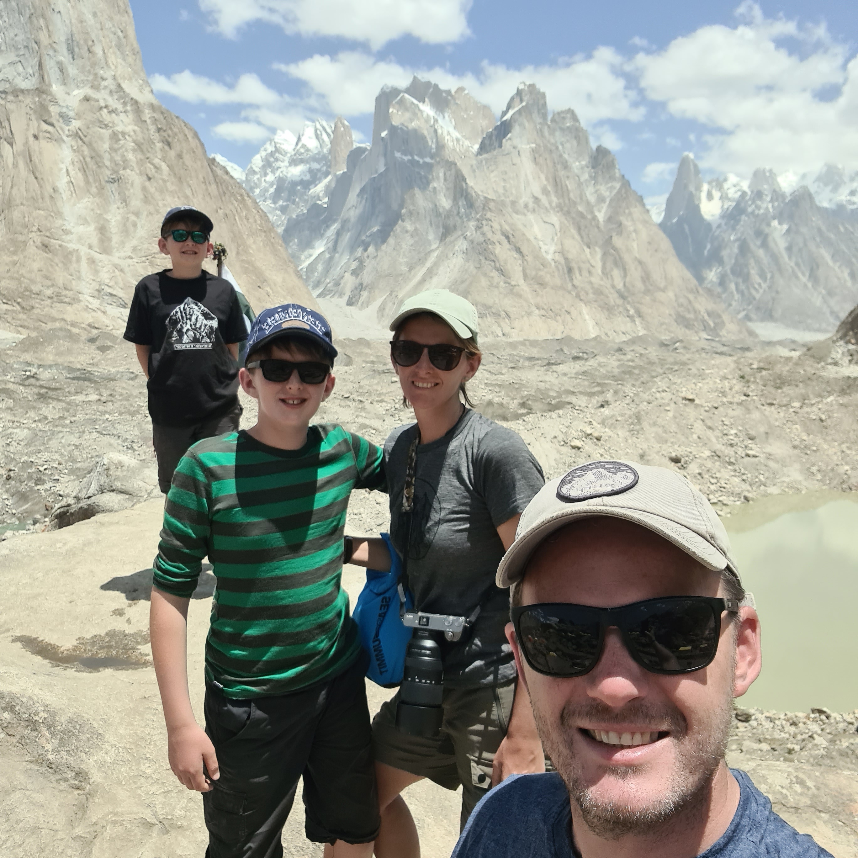 Family standing at a viewpoint with the view behind being the mountains of Pakistan. 