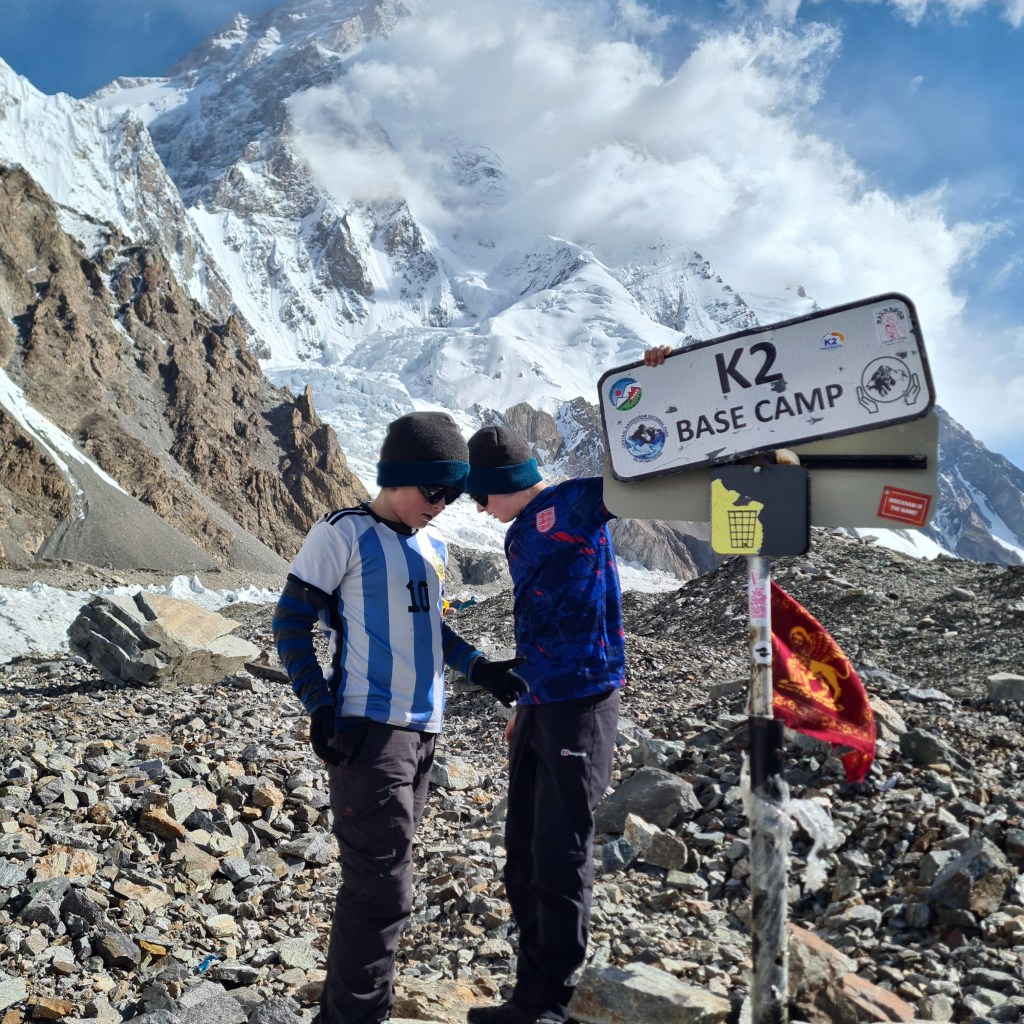 two boys (Ben and Will) at K2 base camp with K2 in the background.