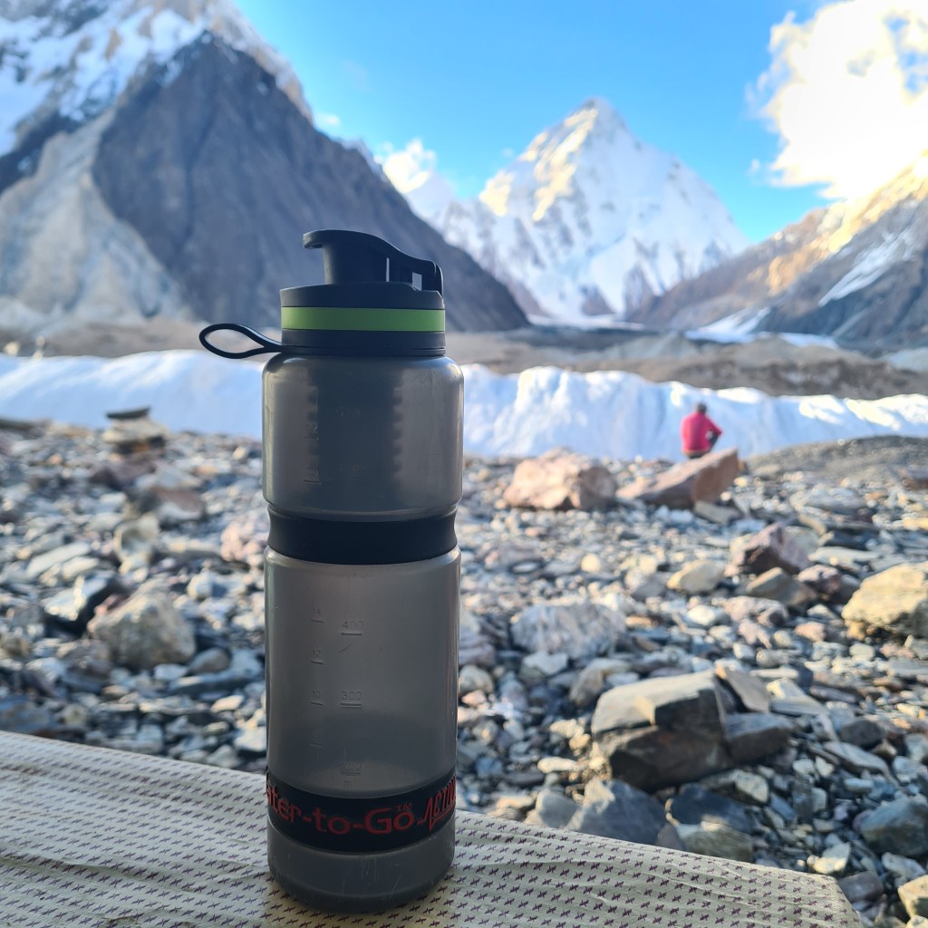 Water to Go bottles are essential for a family hiking in the remote mountains of Pakistan. Here is one of our 6 bottles with a view of K2.
