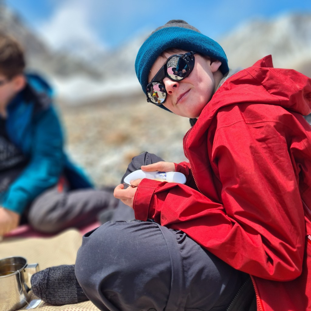 Young boy of family on K2 hike eating snacks on the long journey.