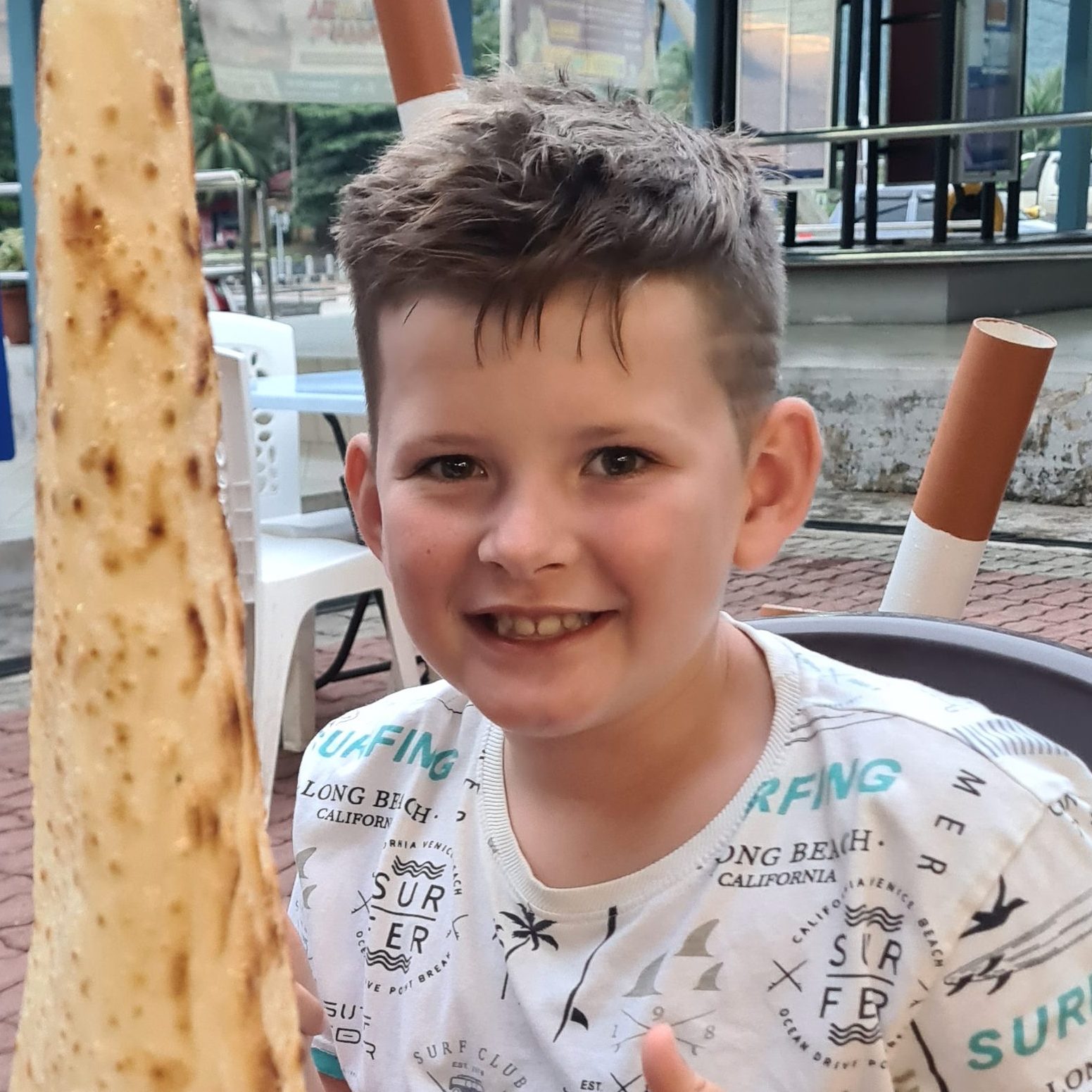 A photo of William smiling with thumbs up. 